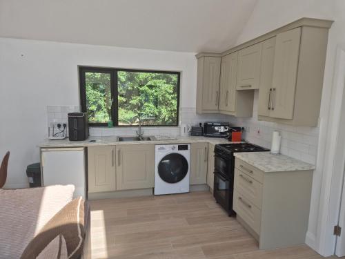 a kitchen with white cabinets and a dishwasher at Farm View Lodge in Kilkenny