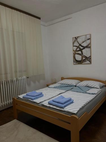 a bedroom with a bed with blue towels on it at msapartman in Surčin