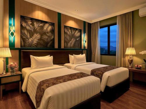 a hotel room with two beds and a window at Bona Ventura Hotel & Skybar in Tanjung Pinang 