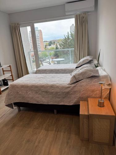 a bedroom with a large bed and a large window at Mono 611 in Neuquén