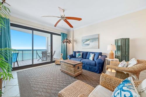 a living room with a blue couch and a table at Grand Pointe Unit 706 in Orange Beach