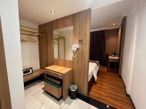 a hotel room with a bed and a phone on the wall at Bona Ventura Hotel & Skybar in Tanjung Pinang 