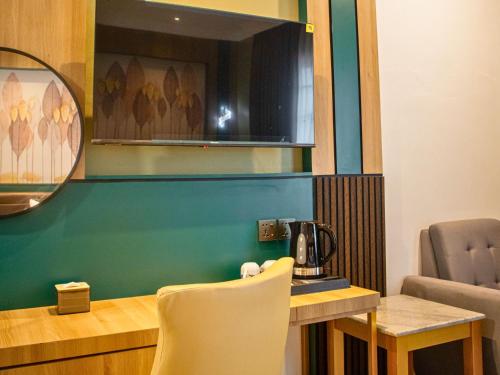a room with a table and chairs and a mirror at Bona Ventura Hotel & Skybar in Tanjung Pinang 