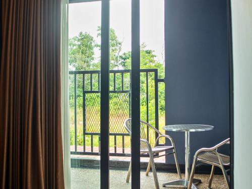 a room with a balcony with a table and chairs at Bona Ventura Hotel & Skybar in Tanjung Pinang 