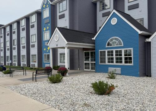 a blue building with benches in front of it at BlissPoint Inn & Suites, Northwood in Northwood