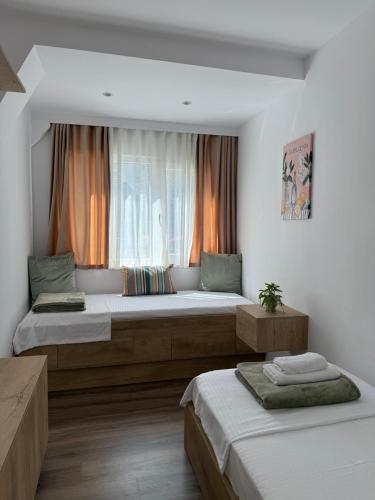 a bedroom with two beds and a window at Lemon Garden Cozy 2BR Apt Private Garden Center in Tirana