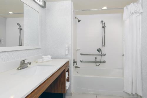 a white bathroom with a shower and a sink at Home2 Suites By Hilton Nokomis in Nokomis