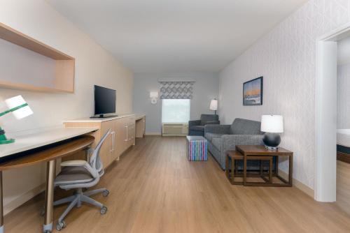 a living room with a couch and a desk with a computer at Home2 Suites By Hilton Nokomis in Nokomis