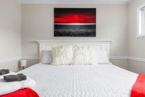 a bedroom with a white bed with a painting on the wall at Pleasant Valley Resort in Arcadia
