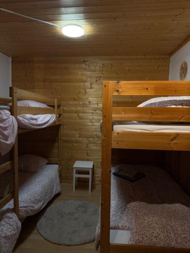 a room with three bunk beds in a cabin at La clé de la forêt in Métairies-Saint-Quirin