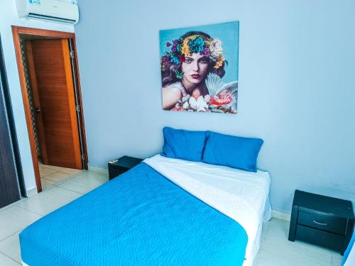 a blue room with a bed with a painting on the wall at Golden Sun Penthouse VIP in Playa Blanca