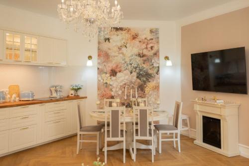 a dining room with a table and chairs and a painting at Tynska apartment in Prague