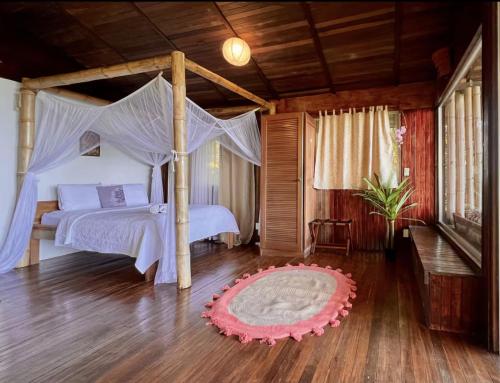 a bedroom with a canopy bed and a rug at Seaview studio's, free breakfast & park tour in Quepos