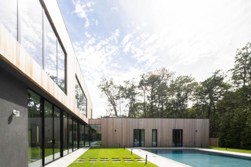 a house with a swimming pool next to a building at Blue Jay Villa by Rove - Family Home with Heated Pool Sauna & Gym in East Hampton