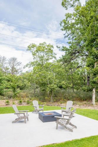 three chairs and a ping pong table on a patio at Blue Jay Villa by Rove - Family Home with Heated Pool Sauna & Gym in East Hampton