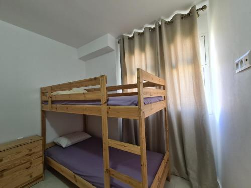 Etagenbett in einem kleinen Zimmer mit Etagenbett in einem Zimmer in der Unterkunft Très Joli Appartement en résidence avec piscine in Cabo Negro