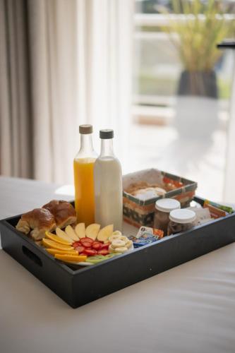 a tray filled with food and bottles of milk at Terrazas Ostende - Apart Hotel in Ostende