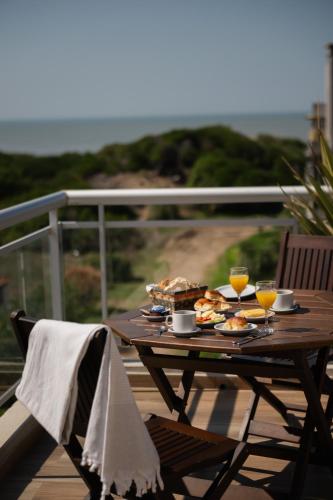 a picnic table with food and drinks on a deck at Terrazas Ostende - Apart Hotel in Ostende