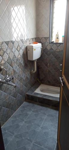 a bathroom with a toilet and a sink at Urvi Girls' Pg in Pune