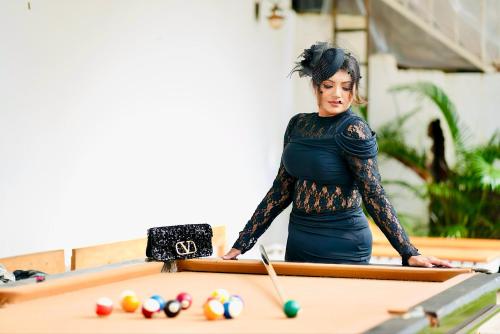 a woman standing in front of a pool table at Beachwaves cottages by Tvessa in Morjim