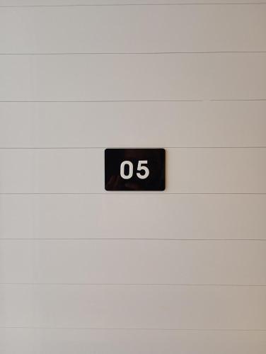 a black clock on a white wall at WeStay Nova Cidade in São Paulo