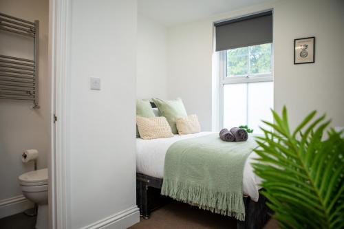 a bedroom with a bed with pillows and a window at St James Court Aparthotel in Derby