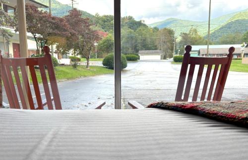 a bedroom with two chairs and a table and a window at Castlewood Inn in Maggie Valley