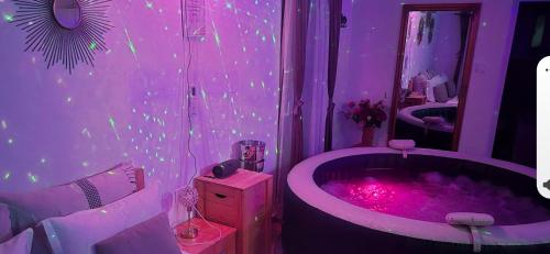 a purple bathroom with a tub with pink lighting at Casuța Casa Dia in Cisnădie