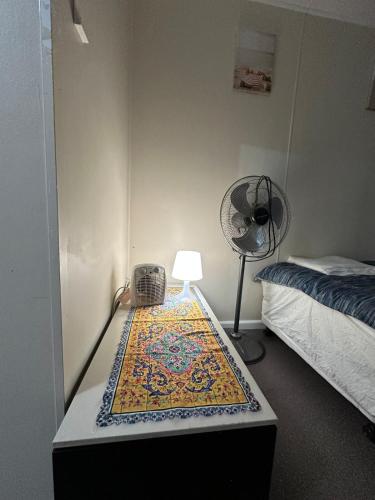 a room with a table with a lamp and a rug at Dural paradise in Dural
