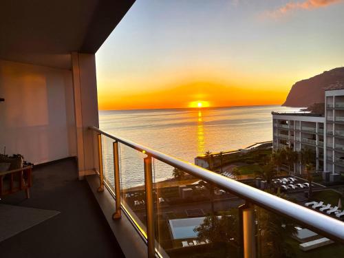 a view of the ocean from a balcony with a sunset at Suite 107 in Funchal
