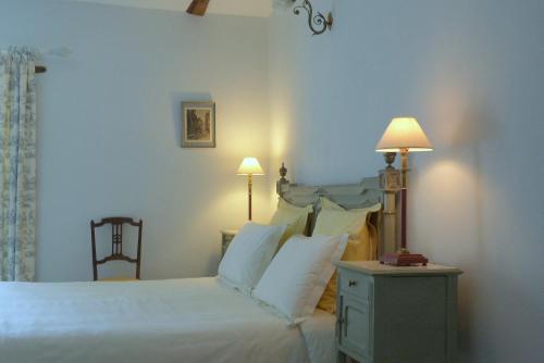 Plouër-sur-RanceにあるAu Pontmevaultのベッドルーム1室(白いシーツと枕のベッド1台付)