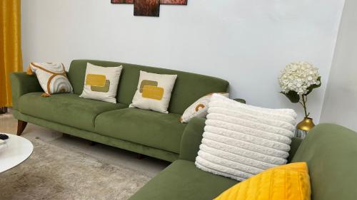 a green couch with pillows in a living room at Résidence FARASELAA in Dakar