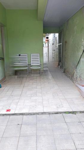 two benches sitting in a room with a green wall at Casa do Pescador in Bertioga