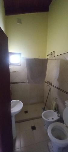 a bathroom with a toilet and a sink at Cabaña Cerca del rio Cabalango in Cavalango