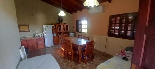 een keuken met een tafel en een witte koelkast bij Cabaña Cerca del rio Cabalango in Cavalango