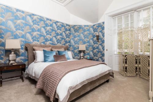a bedroom with a large bed with blue wallpaper at Firlands in Forres