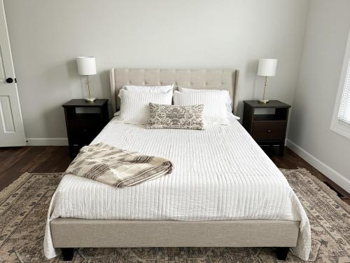 a bedroom with a bed with two night stands and two lamps at Modern 4 BDRM Renovated Spacious near U of E and Downtown in Evansville