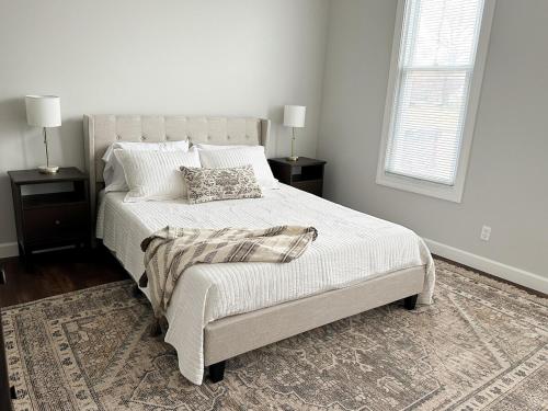 a white bedroom with a bed and a window at Modern 4 BDRM Renovated Spacious near U of E and Downtown in Evansville