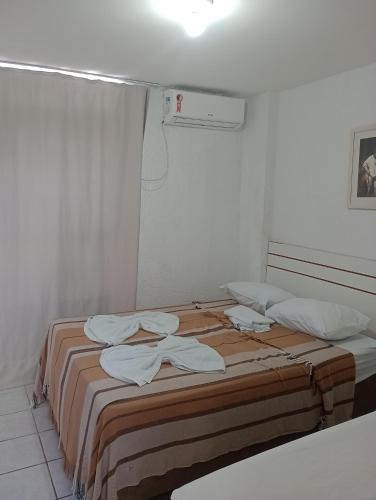 a bedroom with a bed with towels on it at Portugal Flat in João Pessoa