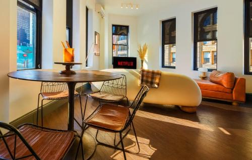 a living room with a couch and a table and chairs at Remodeled 2BR Downtown Near Acrisure Stadium in Pittsburgh