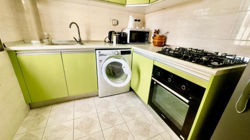 a kitchen with a stove and a washing machine at Résidence FARASELAA in Dakar