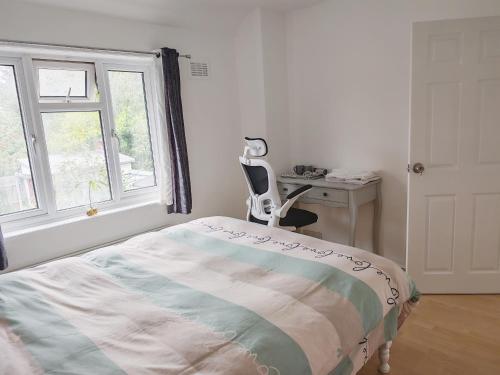 a bedroom with a bed and a desk and a chair at Home too in London