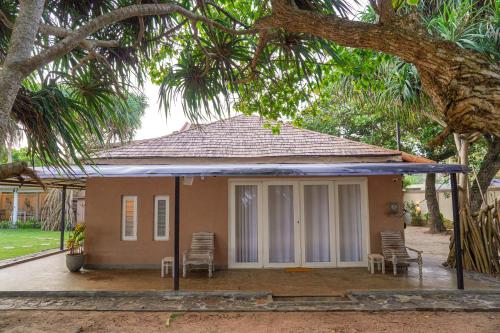 a small house with chairs and a porch at Exotica Bungalows -Hikkaduwa in Hikkaduwa