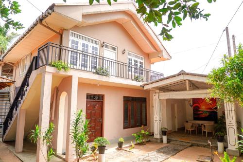 a house with a balcony on top of it at Exotica Bungalows -Hikkaduwa in Hikkaduwa
