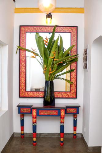 a vase with flowers on a table in front of a mirror at Exotica Bungalows -Hikkaduwa in Hikkaduwa