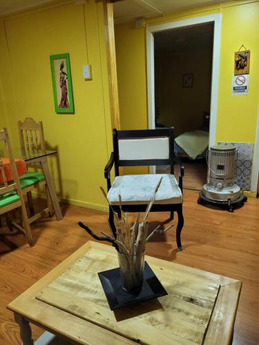 a living room with a table and a chair at CABAÑAS RINCON SOLEADO, Chile Chico in Chile Chico