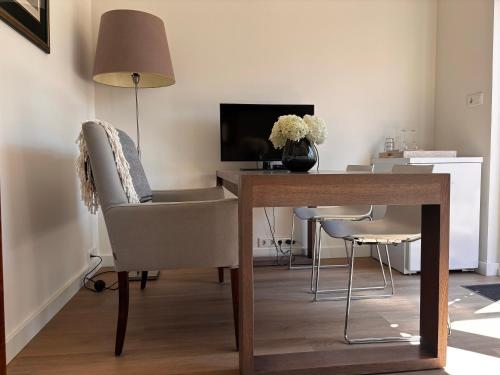 a room with a desk with a lamp and a chair at Guesthouse Mamaloutje in Bemmel