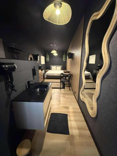 a bathroom with a sink and a bedroom with a bed at Au bât Tournai chambre Bohème in Tournai
