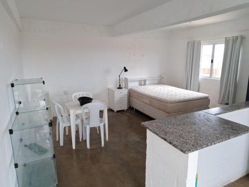 a room with a bed and a table and chairs at KIT Rayar in Alto Paraíso de Goiás