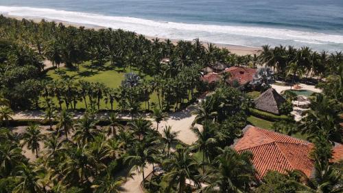 an aerial view of a resort with palm trees and the beach at Puertas Paraíso Hotel boutique in Zihuatanejo